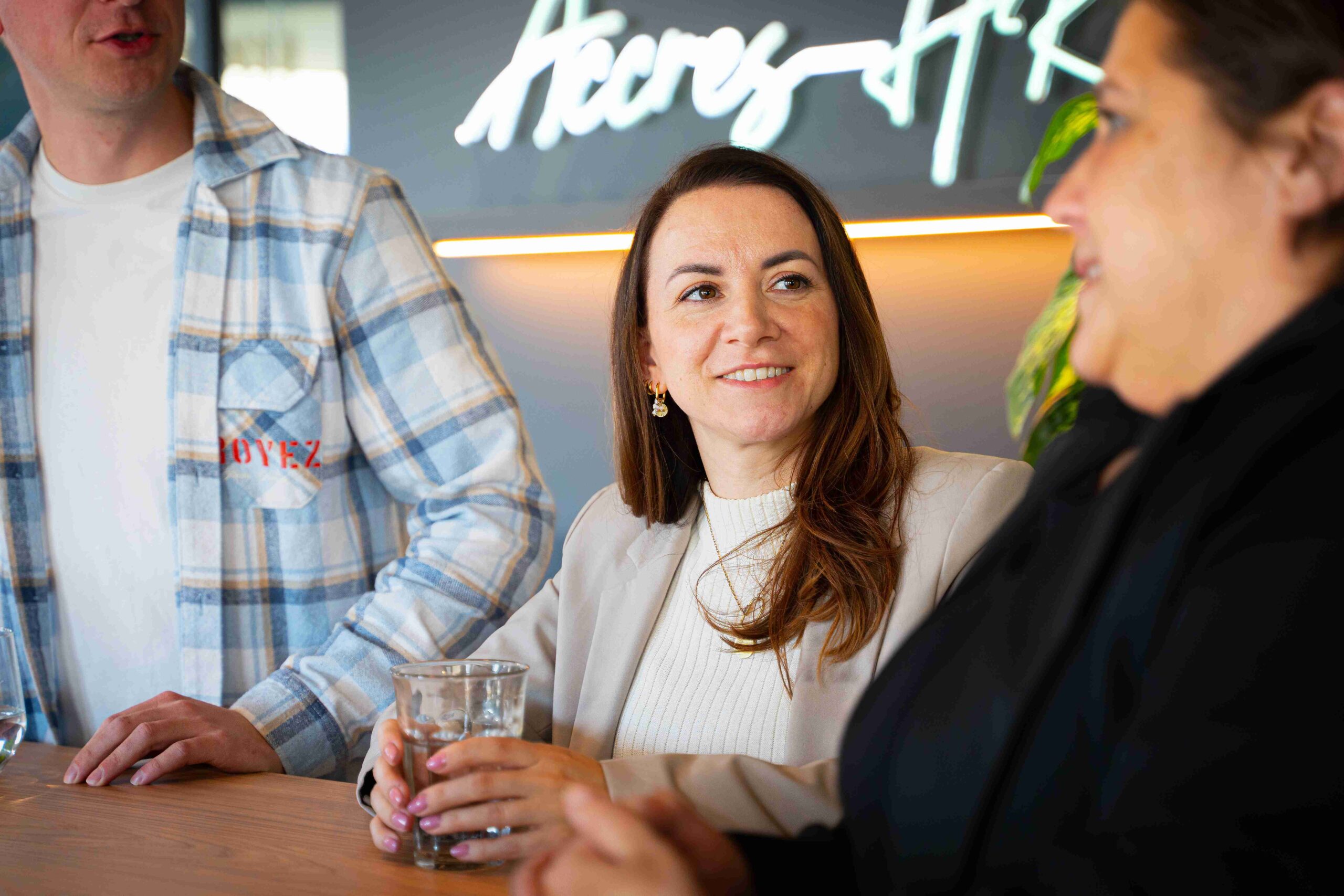 Lachende medewerker aan bar met glas water